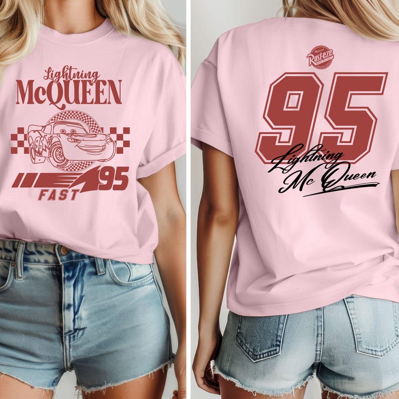 May include: Pink t-shirt with a red graphic of Lightning McQueen, the number 95, and the words "Lightning McQueen" and "Fast". The back of the shirt has a red number 95 with the words "Lightning McQueen" in black.