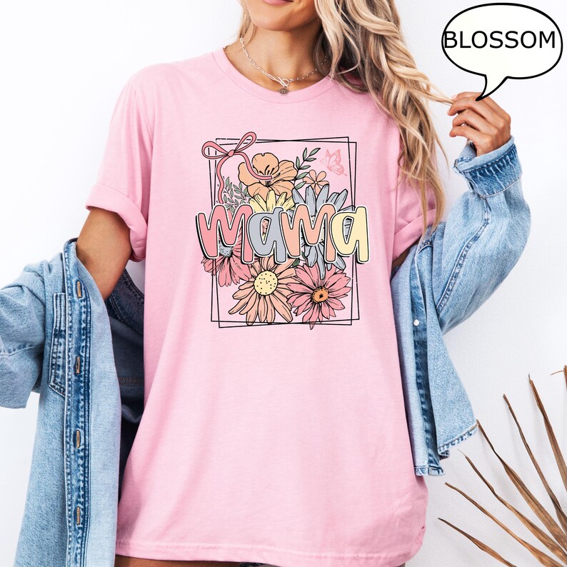 May include: Pink t-shirt with a floral design and the word "mama" in a colorful font.