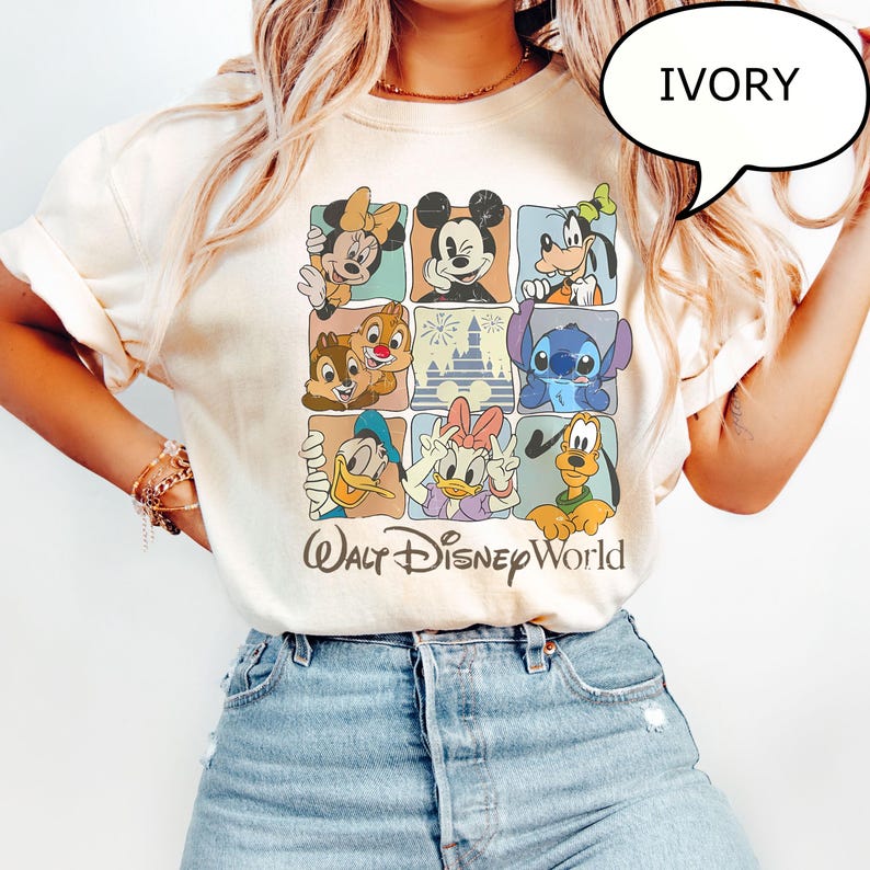 May include: Ivory-colored t-shirt featuring a grid of Disney characters including Mickey Mouse, Minnie Mouse, Goofy, Donald Duck, and Stitch. The words "Walt Disney World" are printed in a stylized font below the grid.