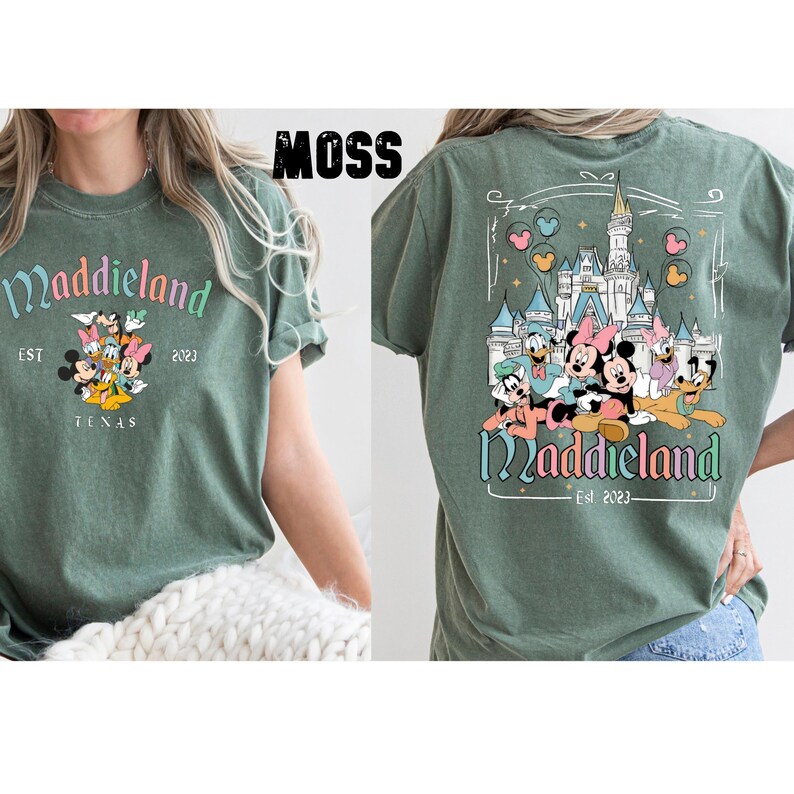 K&ouml;nnte beinhalten: Ein gr&uuml;nes T-Shirt mit einem Aufdruck von Mickey Mouse und seinen Freunden vor einem Schloss. Der Text "Maddieland Est 2023" ist auf dem T-Shirt gedruckt.