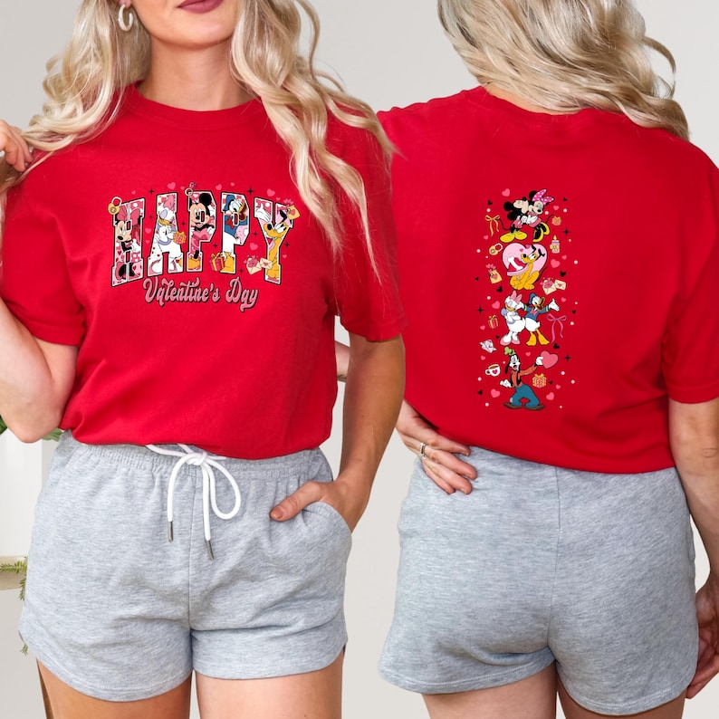 May include: Red t-shirt with the text "HAPPY Valentine's Day" in a colorful design featuring Disney characters. The back of the shirt has a vertical design with Disney characters and hearts. The shirt is paired with gray shorts.