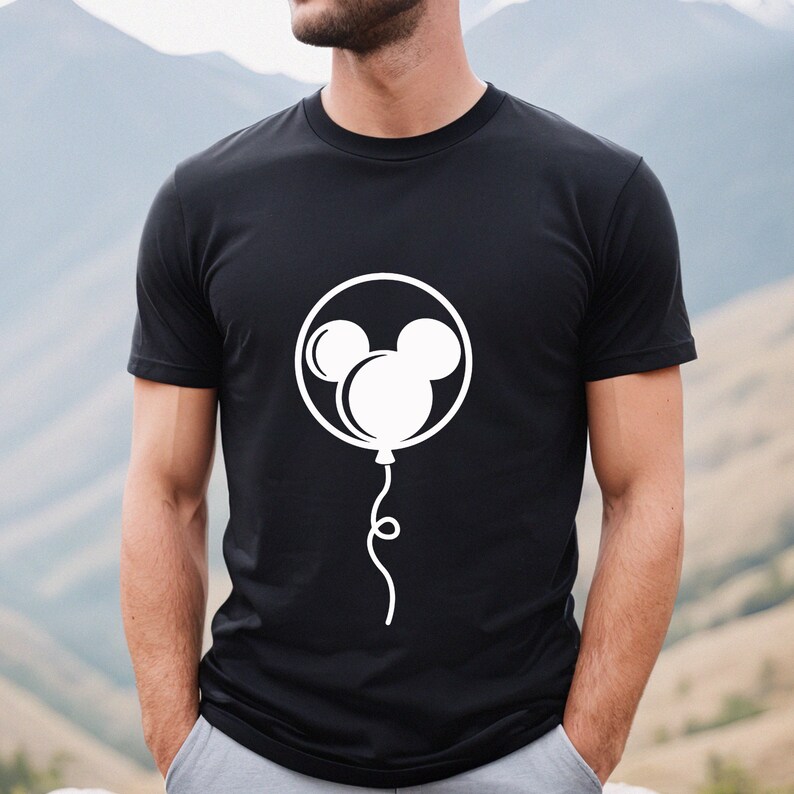 Pode incluir: Camiseta preta com um gr&aacute;fico branco de uma cabe&ccedil;a do Mickey Mouse dentro de um bal&atilde;o.