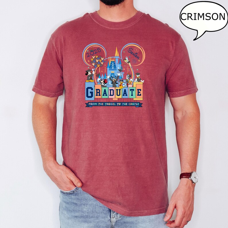 以下が含まれることがあります： ミッキーマウスとその仲間たちが卒業を祝うグラフィックがプリントされた、クリムゾンレッドのTシャツ。シャツのテキストは「2025 Senior Graduate From the Tassel to the Castle」です。