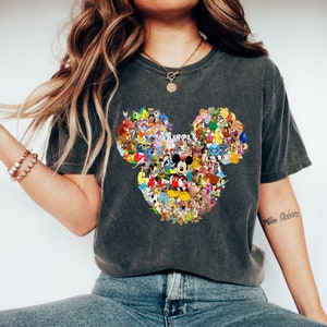 May include: A dark gray t-shirt with a large Mickey Mouse head design made up of various Disney characters. The design is in a collage style with many different colors and characters.