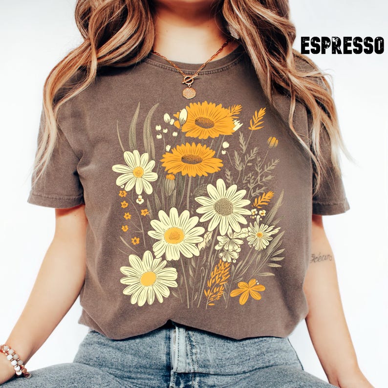 May include: Espresso-colored t-shirt featuring a floral design with yellow and white daisies and sunflowers. The graphic includes various leaves and stems. The word "ESPRESSO" is printed in bold, black letters at the top right.