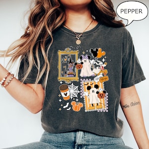 Może przedstawiać: Ciemnoszara koszulka z motywem Halloween z postaciami z kresk&oacute;wek, dyniami i zamkiem. Słowo "Pepper" znajduje się w dymku. Projekt zawiera słowa "Magic Magic".