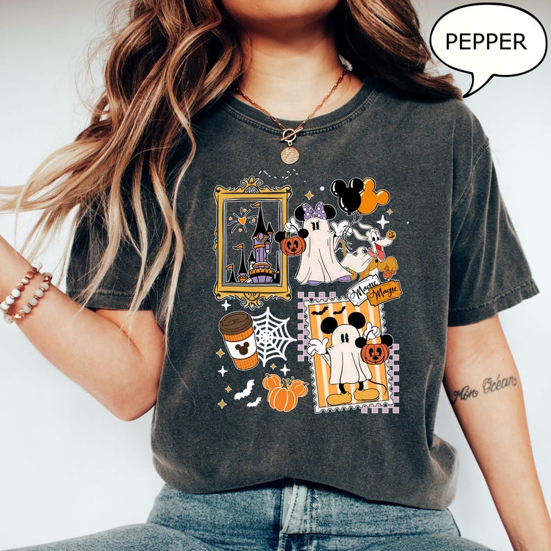 Może przedstawiać: Ciemnoszara koszulka z motywem Halloween z postaciami z kresk&oacute;wek, dyniami i zamkiem. Słowo "Pepper" znajduje się w dymku. Projekt zawiera słowa "Magic Magic".