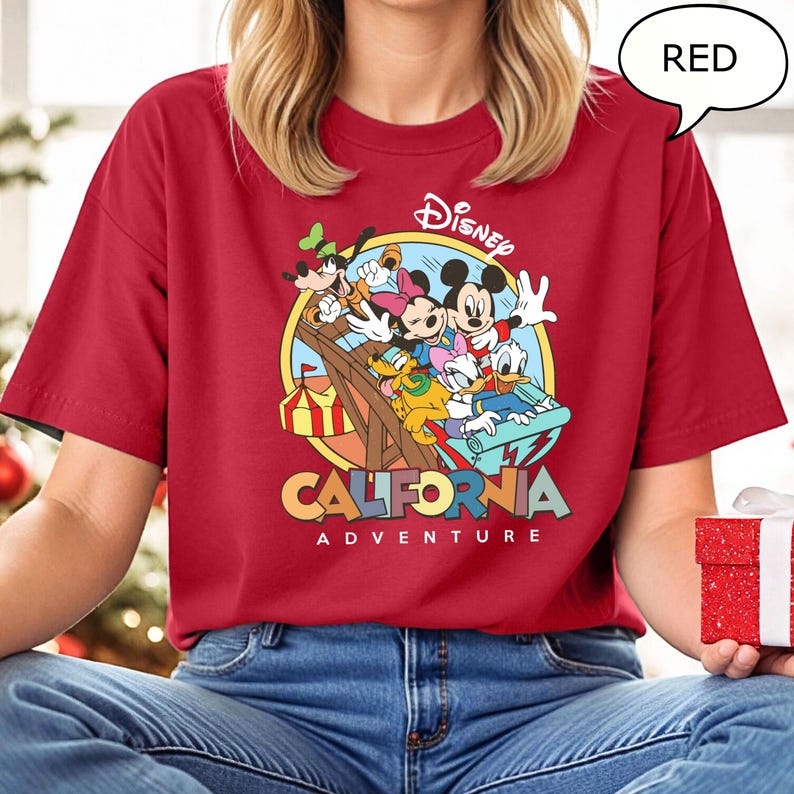 Puede incluir: Camiseta roja con un gr&aacute;fico de Mickey Mouse y sus amigos montando una monta&ntilde;a rusa. El gr&aacute;fico incluye el texto "Disney California Adventure".