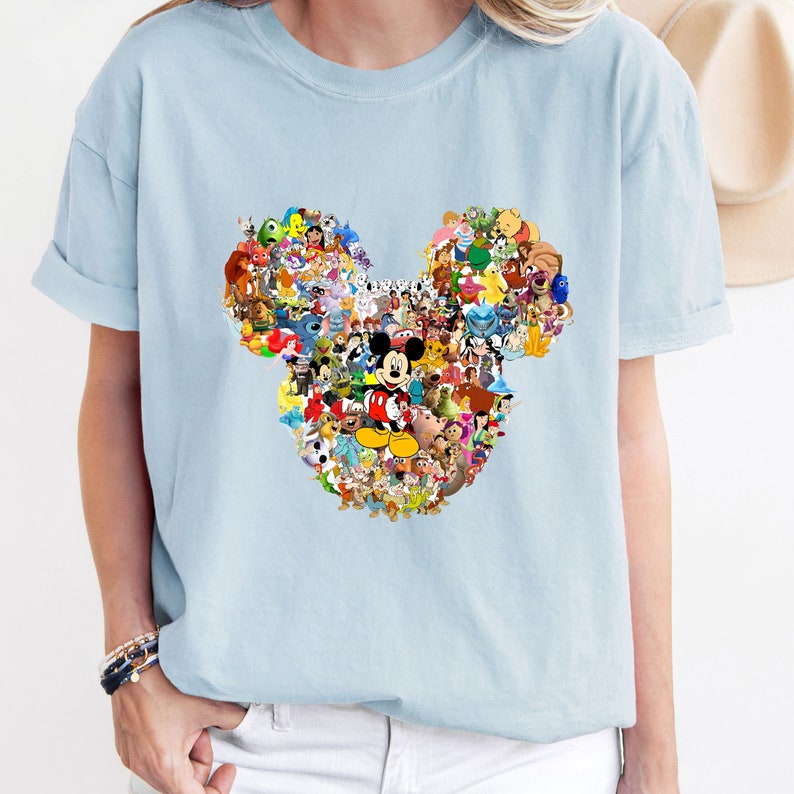 May include: Light blue t-shirt with a graphic of Mickey Mouse's ears made up of various Disney characters.