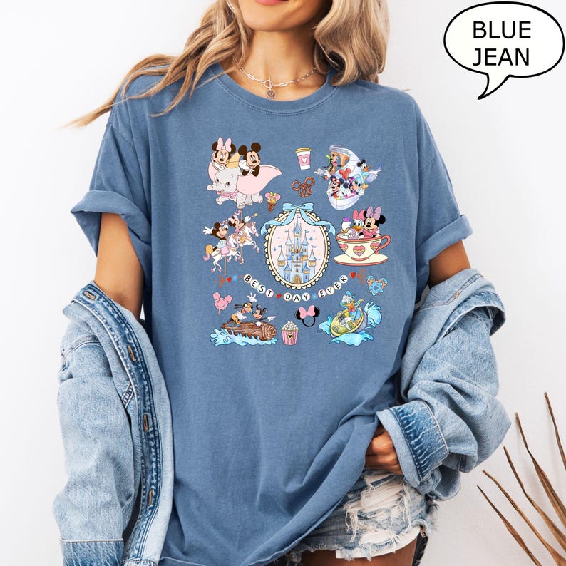 Puede incluir: Camiseta azul vaquero con un dise&ntilde;o de Disney. El dise&ntilde;o incluye a Mickey y Minnie Mouse, un castillo y el texto "Best Day Ever". La camiseta tiene mangas enrolladas y un corte holgado.