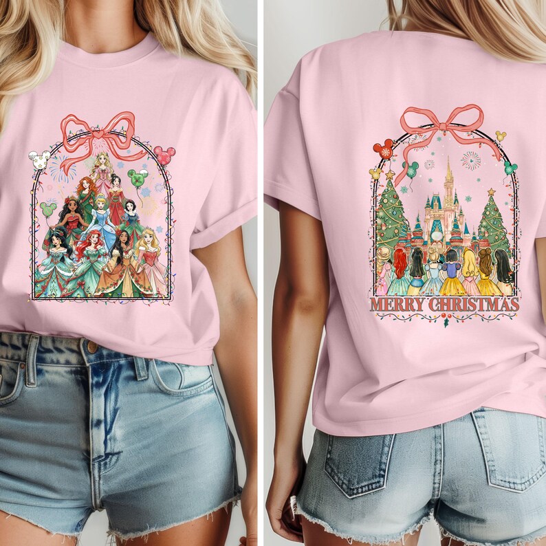 May include: Pale pink t-shirt with a cartoon princess design on the front, framed by a bow and balloons. The back displays a castle, Christmas trees, and the text "MERRY CHRISTMAS".