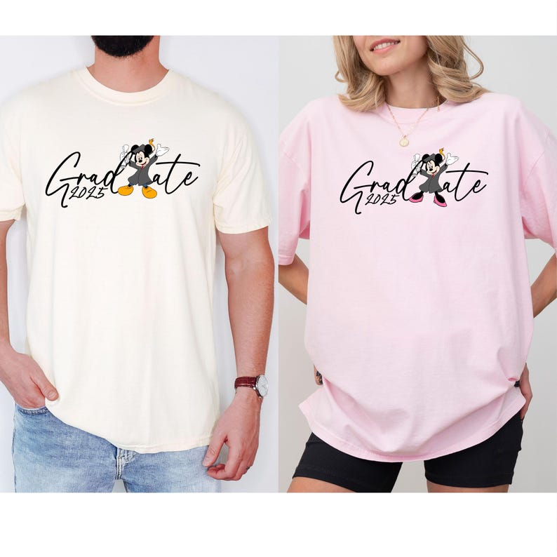 Puede incluir: Dos camisetas con un tema de graduaci&oacute;n. Una es de color crema y la otra es rosa. Ambas camisetas presentan una imagen de dibujos animados de Mickey Mouse con una gorra y una bata de graduaci&oacute;n. El texto "Graduate 2023" est&aacute; impreso en ambas camisetas.