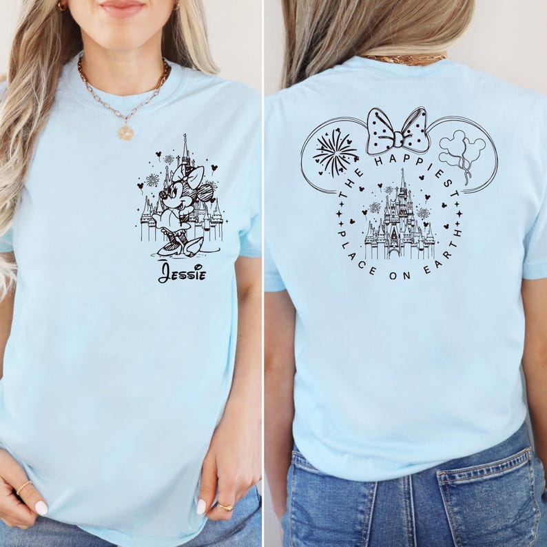 K&ouml;nnte beinhalten: Hellblaues T-Shirt mit einer schwarz-wei&szlig;en Illustration von Mickey Mouse und dem Text "Jessie" auf der Vorderseite. Die R&uuml;ckseite des Shirts zeigt eine schwarz-wei&szlig;e Illustration von Schloss Aschenputtel mit dem Text "The Happiest Place on Earth" in Form eines Mickey-Mouse-Ohrs.