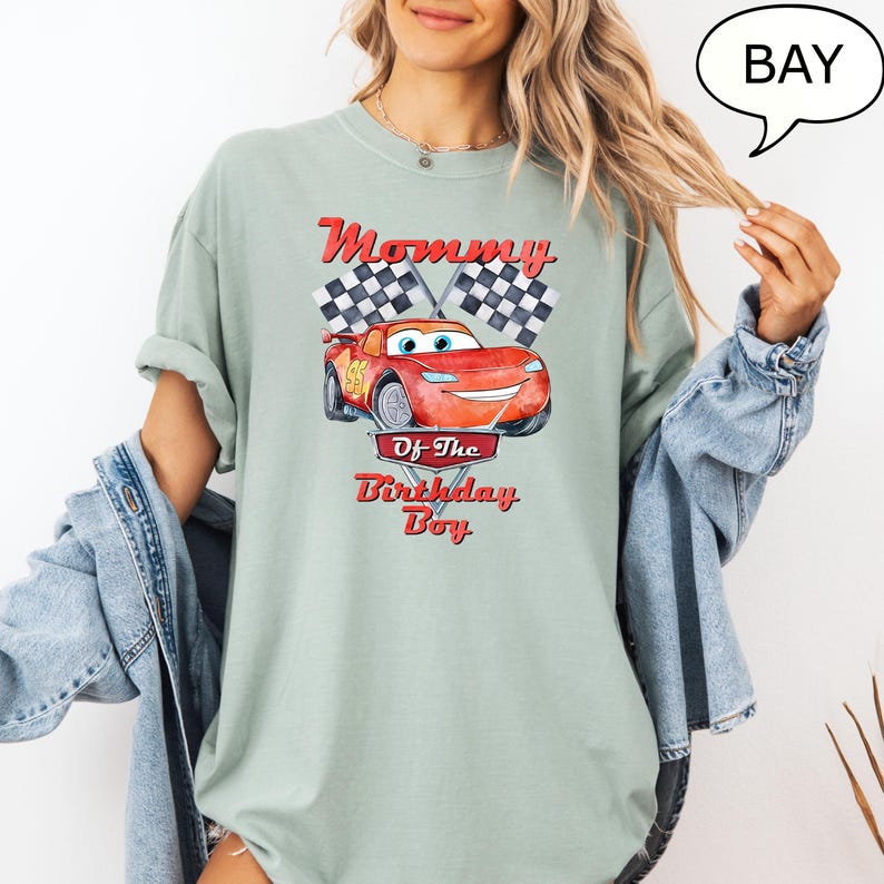 Puede incluir: Una camiseta verde claro con un coche de carreras rojo y banderas a cuadros. El texto "Mommy of the Birthday Boy" est&aacute; impreso en la camiseta.