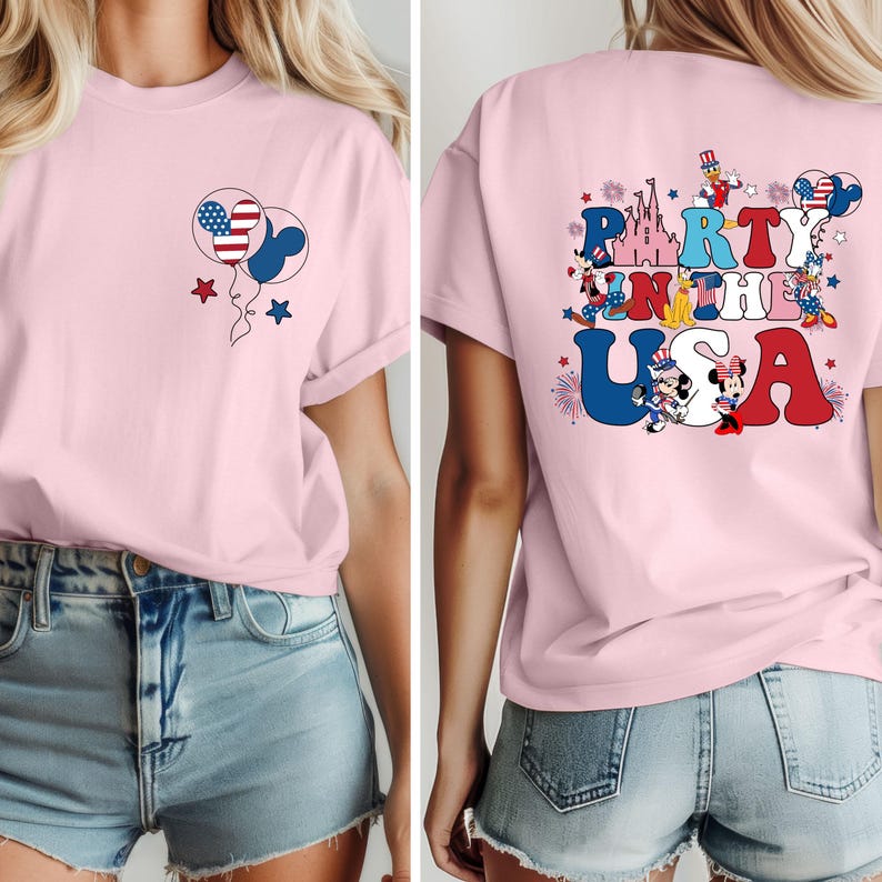 K&ouml;nnte beinhalten: Ein hellrosa T-Shirt mit einem patriotischen Design. Die Vorderseite zeigt Ballons mit amerikanischen Flaggenmustern und Sternen. Auf der R&uuml;ckseite des Shirts steht der Text "Party in the USA" mit Zeichentrickfiguren und einem Schloss.
