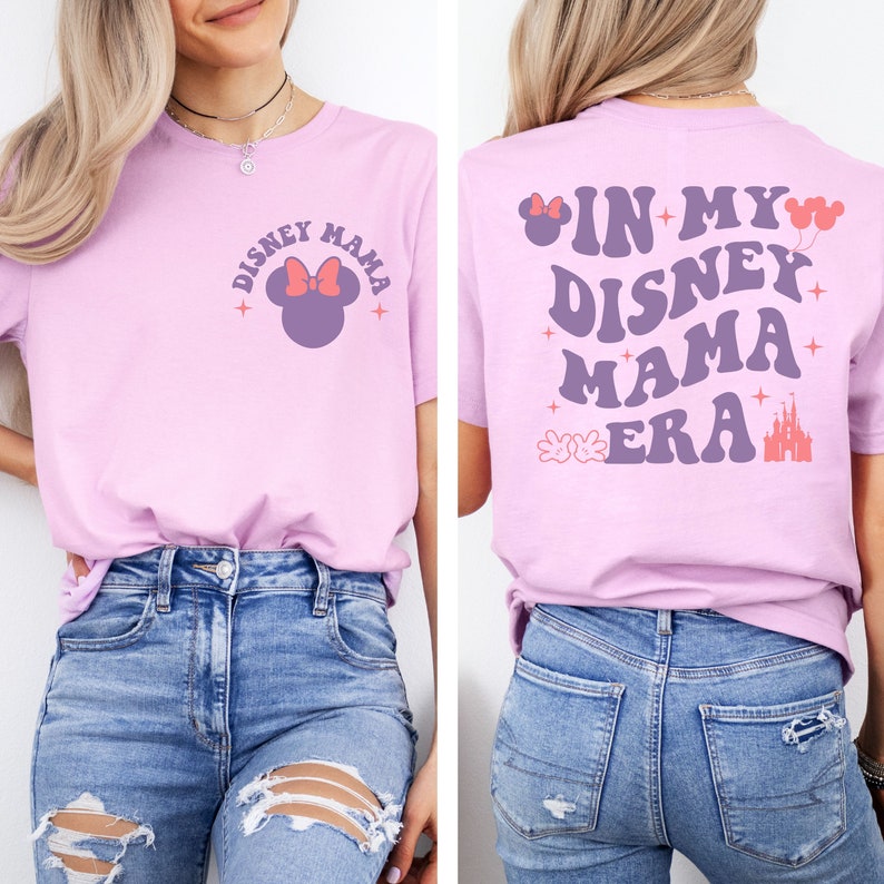 May include: A lilac t-shirt with the text "Disney Mama" and a Minnie Mouse graphic on the front. The back of the shirt features the text "In My Disney Mama Era" with additional graphics including a castle and Mickey Mouse hands.