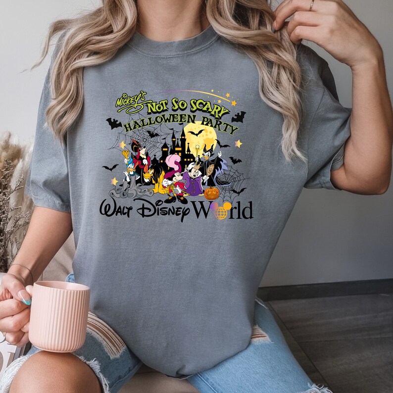 May include: Gray t-shirt with a graphic of Mickey Mouse and friends in a Halloween scene. The text reads "Mickey's Not So Scary Halloween Party Walt Disney World".