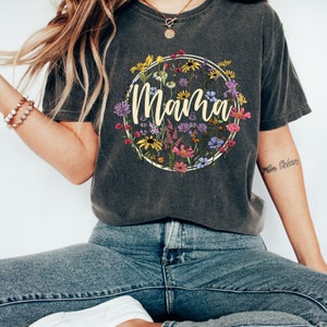 Peut inclure: Un t-shirt gris fonc&eacute; avec un motif circulaire floral et le mot "Mama" en jaune.
