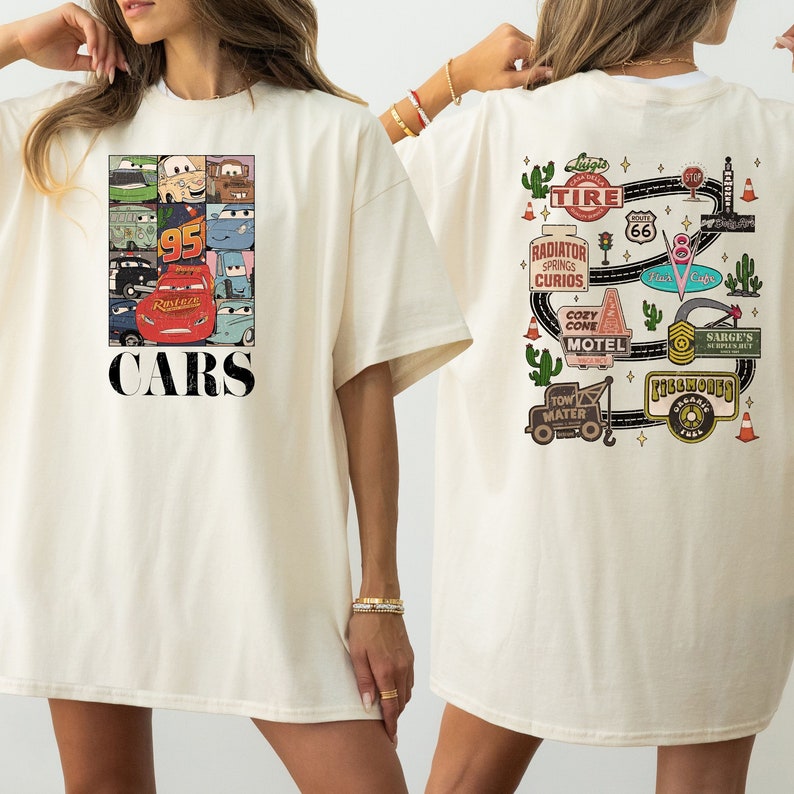 Puede incluir: Una camiseta blanca con un dise&ntilde;o tem&aacute;tico de Cars. La parte delantera de la camiseta presenta un collage de personajes de Cars, incluyendo Rayo McQueen, Mate y otros. La parte posterior de la camiseta presenta un mapa de carreteras con varios puntos de referencia de la pel&iacute;cula Cars, incluyendo Radiador Springs, el Motel Cozy Cone y la tienda de excedentes de Sarge.