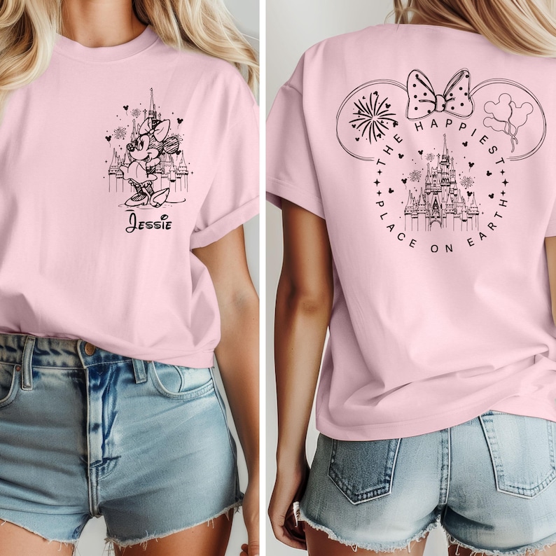 K&ouml;nnte beinhalten: Rosa T-Shirt mit einer schwarz-wei&szlig;en Illustration von Minnie Maus vor dem Schloss von Aschenputtel. Die R&uuml;ckseite des Shirts zeigt eine schwarz-wei&szlig;e Illustration von Aschenputtels Schloss mit dem Text "The Happiest Place on Earth".