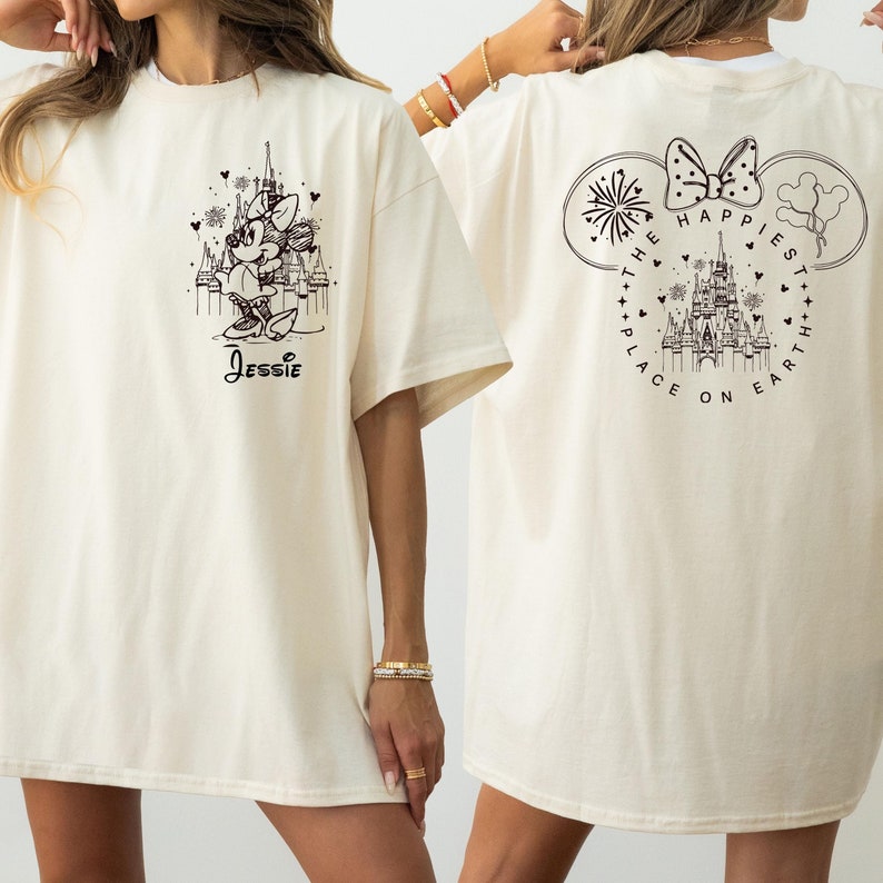 K&ouml;nnte beinhalten: Ein wei&szlig;es T-Shirt mit einem schwarzen Aufdruck von Mickey Mouse und dem Text "Jessie" auf der Vorderseite. Die R&uuml;ckseite des Shirts zeigt einen schwarzen Aufdruck von Schloss Aschenputtel mit dem Text "The Happiest Place on Earth".