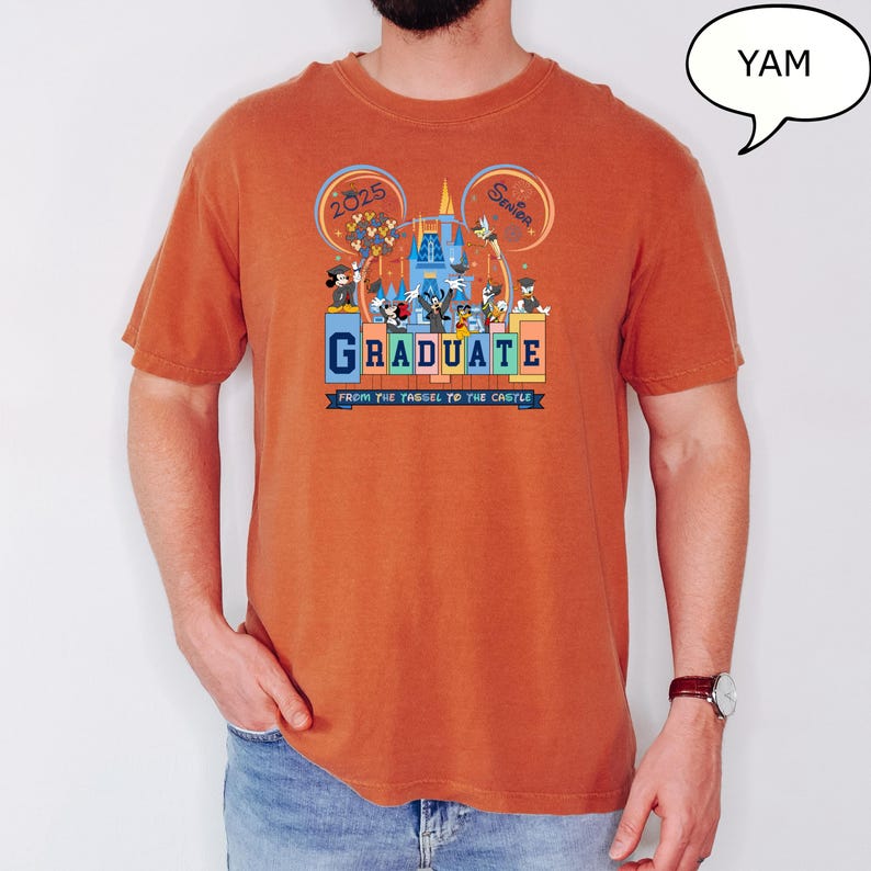 以下が含まれることがあります： さび色のTシャツに、ミッキーマウスとその仲間たちがディズニーワールドで卒業を祝っているグラフィックがプリントされています。Tシャツの文字は「2025 Senior Graduate From the Tassel to the Castle」です。