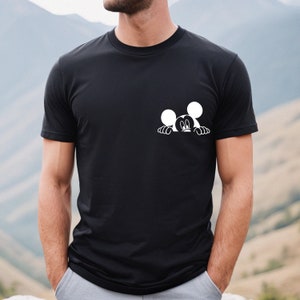 May include: A black t-shirt with a white graphic of Mickey Mouse peeking over the top of the shirt.