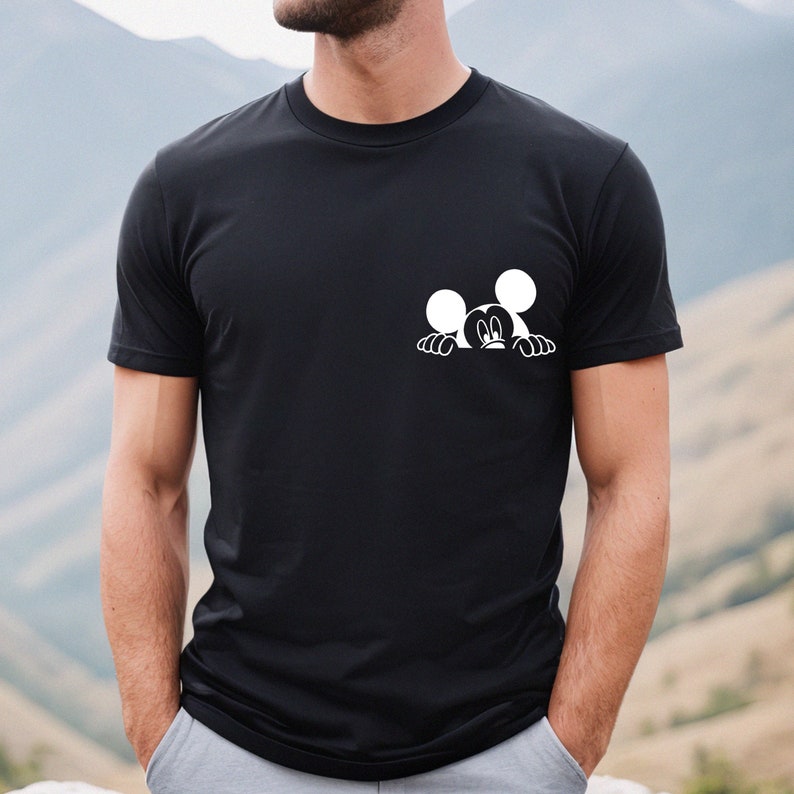 May include: A black t-shirt with a white graphic of Mickey Mouse peeking over the top of the shirt.