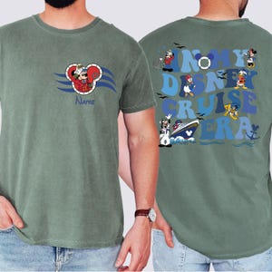Op de afbeelding: Een groen T-shirt met een cartoonafbeelding van Mickey Mouse verkleed als kapitein op de voorkant. De achterkant van het shirt heeft een afbeelding van Mickey Mouse en andere Disney-personages met de tekst "In My Disney Cruise Era".