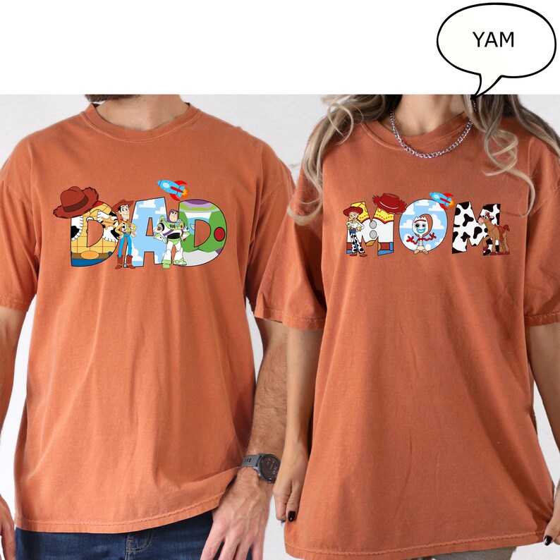 May include: Two orange t-shirts, one with the word "DAD" and the other with "MOM", in a colourful, cartoon style. The "DAD" shirt features characters from a popular animated film. The "MOM" shirt has similar design elements.