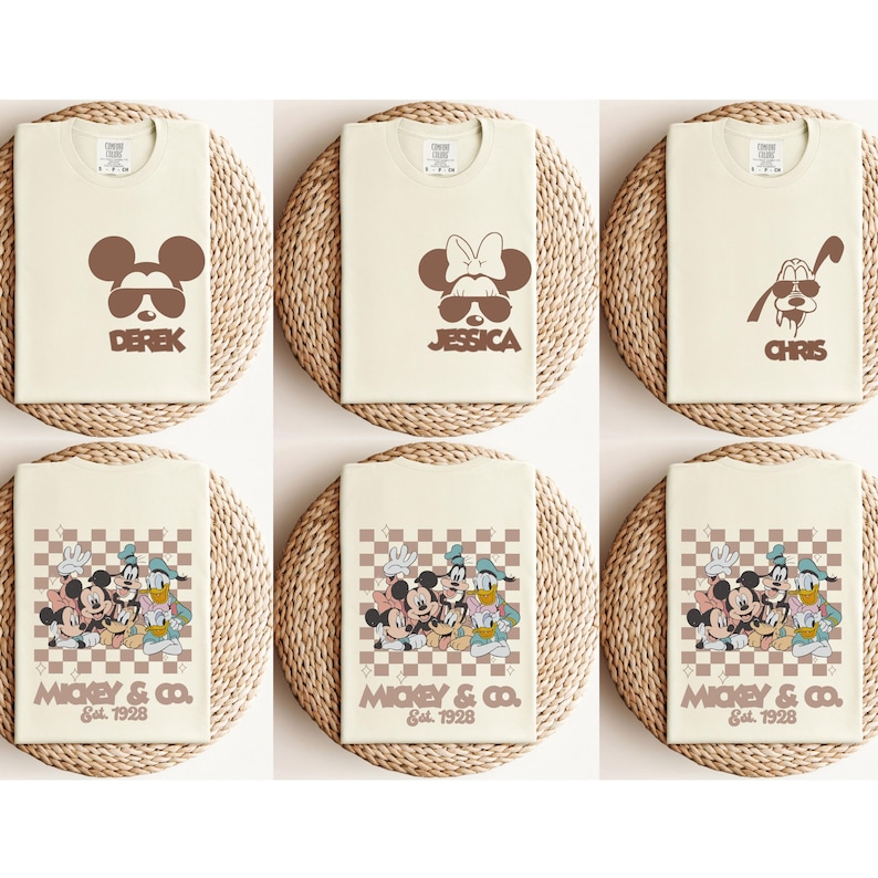 May include: Six cream-colored t-shirts with cartoon graphics. Three shirts feature Mickey Mouse, Minnie Mouse, and Pluto with sunglasses and names. The other three shirts display Mickey & Co. characters with a checkered background and the text "Est. 1928".