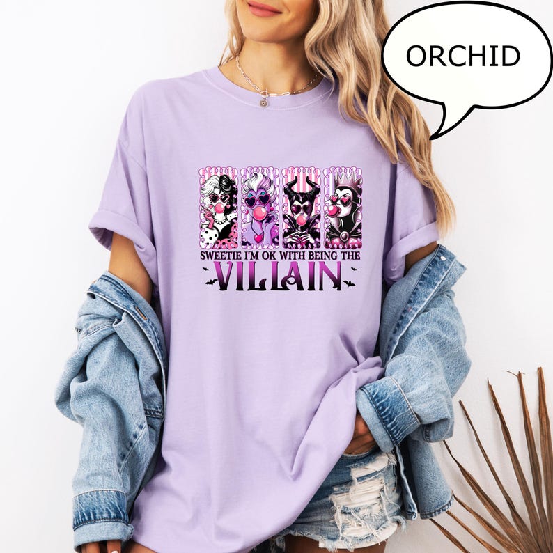 May include: Orchid-colored t-shirt featuring a graphic of four cartoon villains blowing bubble gum. The text reads "Sweetie I'm OK with being the Villain". A speech bubble in the upper right corner says "ORCHID".