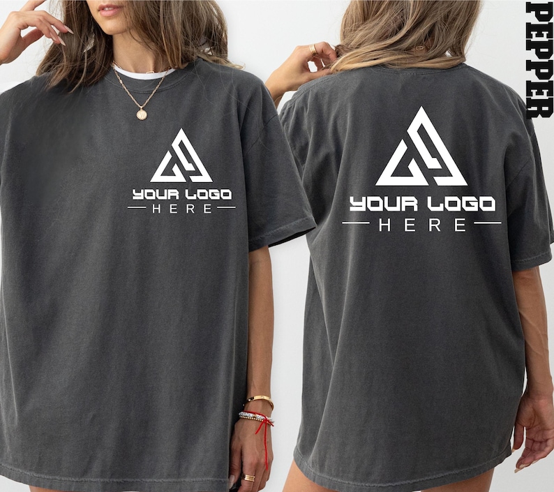 May include: An oversized t-shirt in a dark grey colour with a white triangle logo and the text "YOUR LOGO -HERE- " on the front and back.
