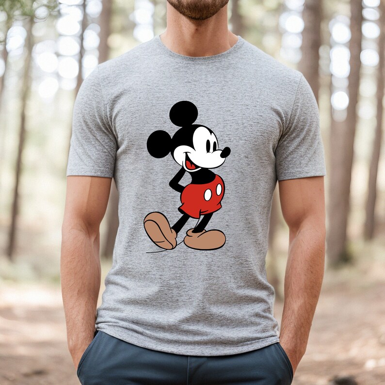 Op de afbeelding: Een grijs T-shirt met een zwart-witte afbeelding van Mickey Mouse met een rode broek.