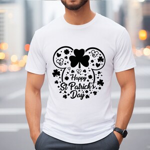 May include: White t-shirt with a black graphic of a Mickey Mouse head made of shamrocks and the text "Happy St. Patrick's Day".