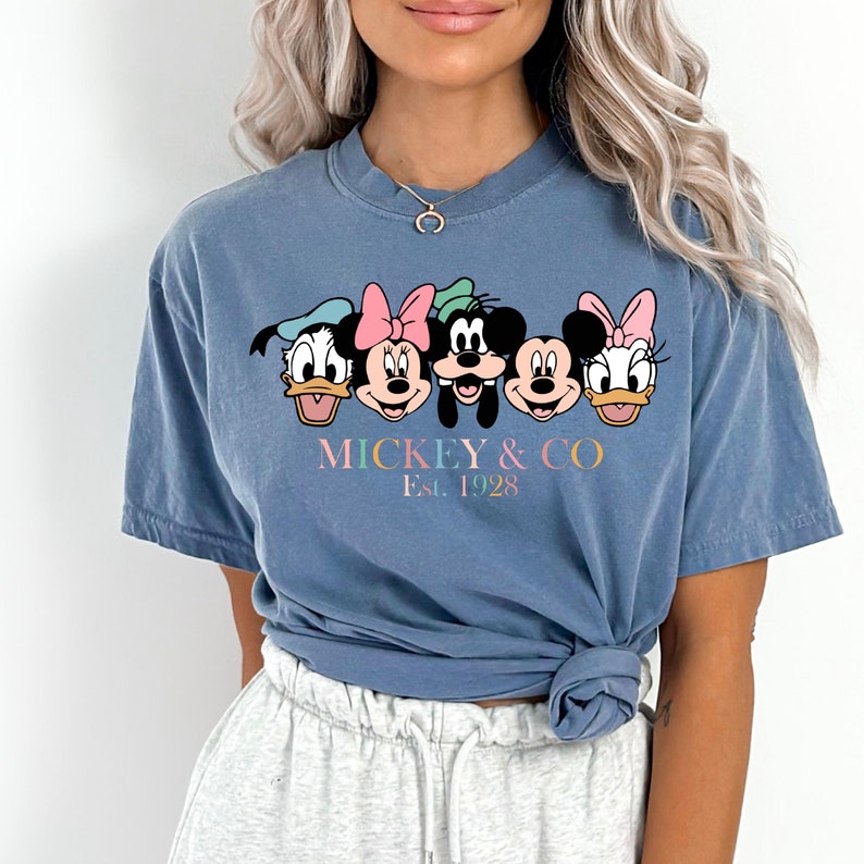 May include: A blue t-shirt with a graphic of Mickey Mouse and friends. The text "MICKEY & CO. Est. 1928" is printed below the graphic.