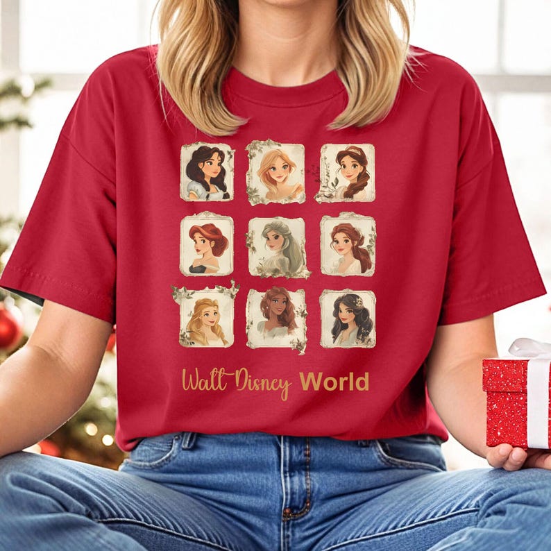 May include: Red t-shirt with a collage of nine Disney princesses in gold frames. The text "Walt Disney World" is printed in gold below the collage.
