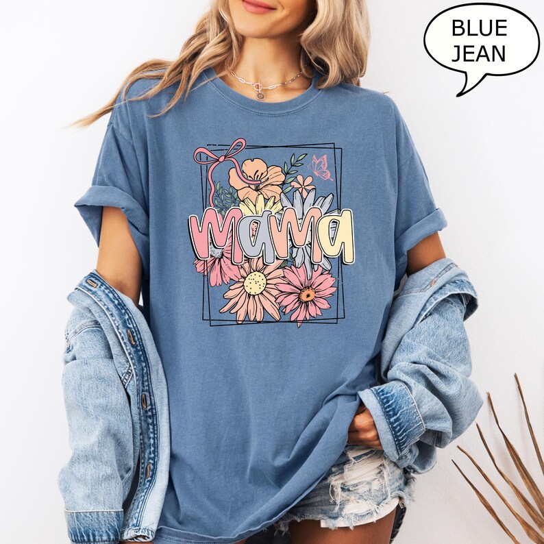 May include: A blue jean t-shirt with a floral design and the word "mama" in a colorful font.