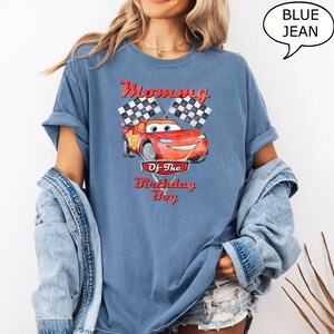 Puede incluir: Una camiseta de mezclilla azul con un coche de carreras rojo de dibujos animados y el texto "Mommy of the Birthday Boy" impreso en ella.