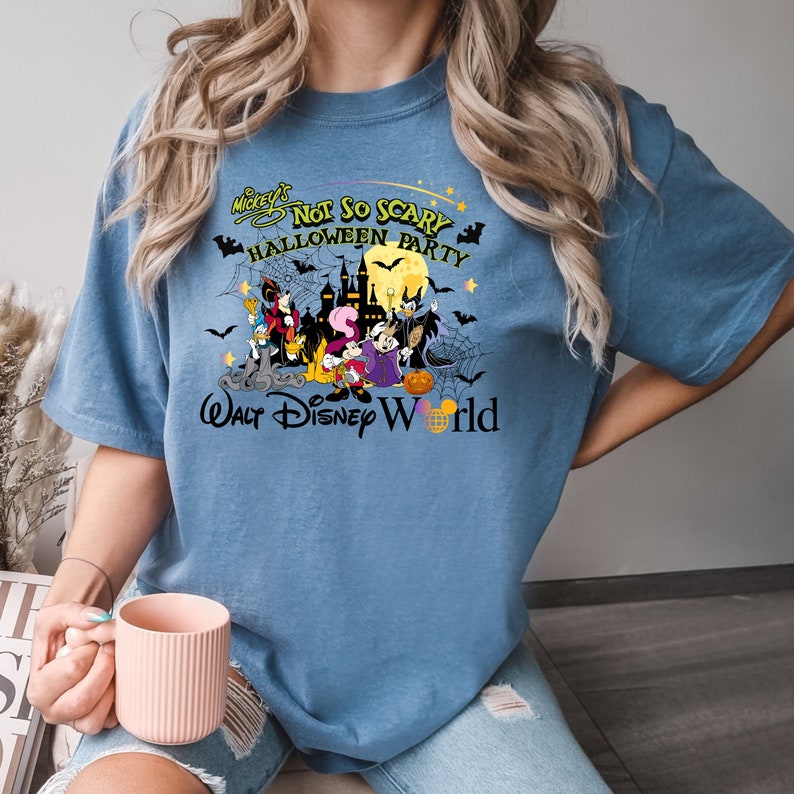 May include: A blue t-shirt with a graphic of Mickey Mouse and friends in Halloween costumes. The text "Mickey's Not So Scary Halloween Party" and "Walt Disney World" are printed on the shirt.