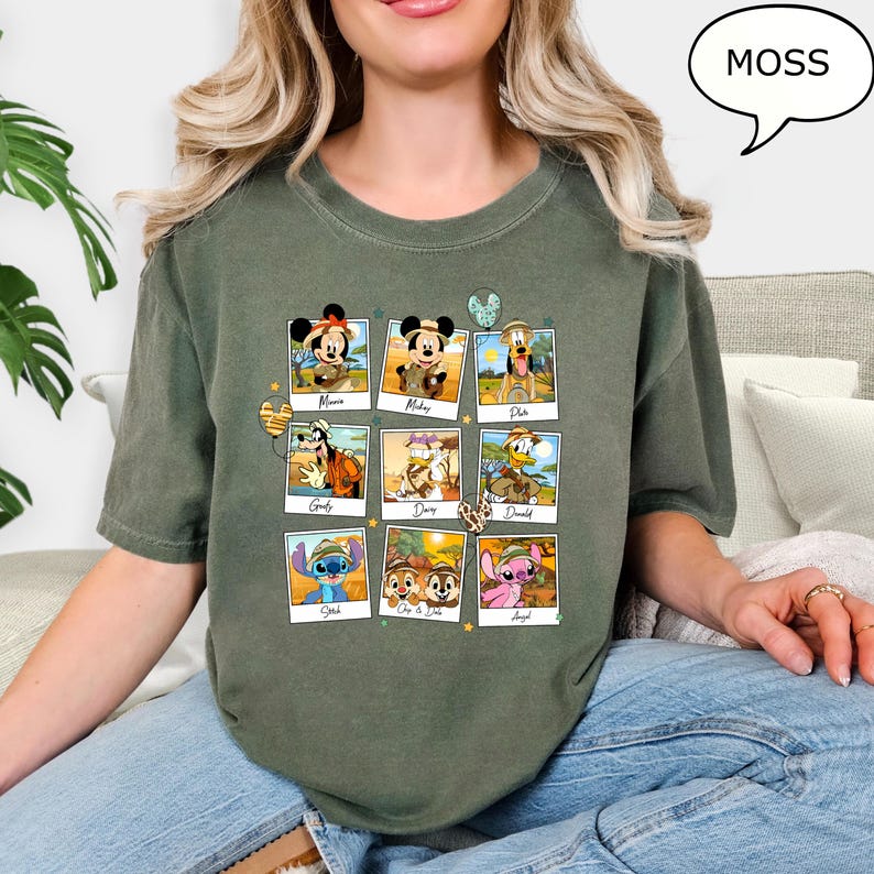 Puede incluir: Una camiseta verde con un collage de personajes de Disney en marcos de fotos. Los personajes incluyen a Mickey Mouse, Minnie Mouse, Pluto, Goofy, Donald Duck, Daisy Duck, Stitch, Lilo y Angel. El texto "MOSS" est&aacute; en un bocadillo de di&aacute;logo en la esquina superior derecha de la imagen.