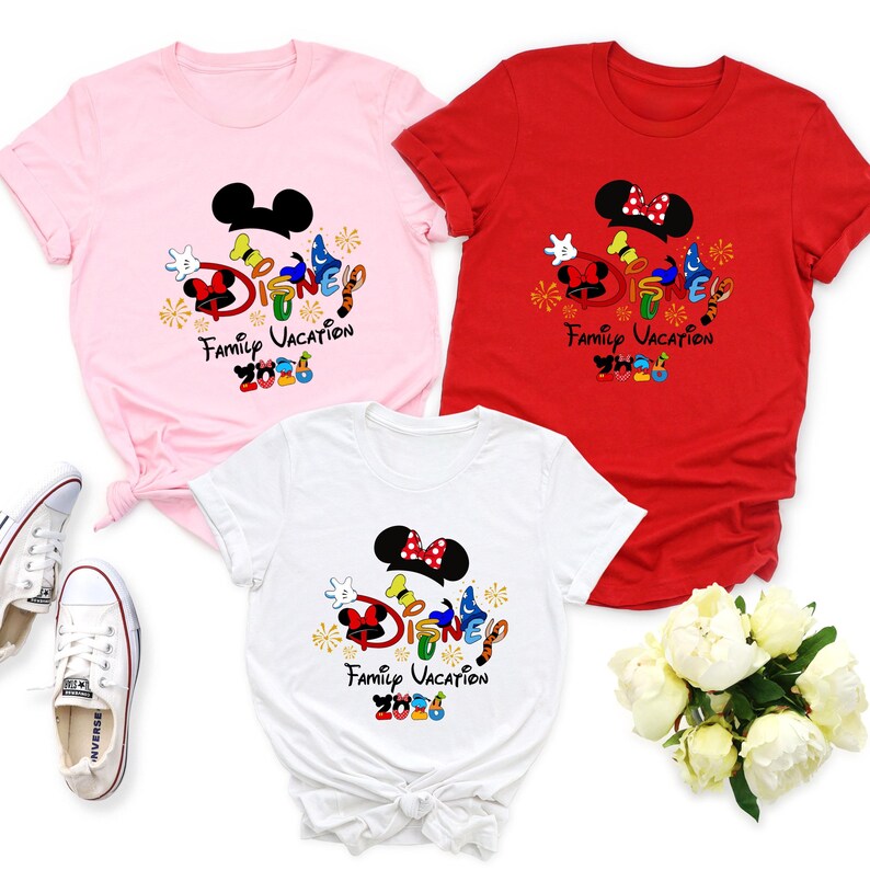 May include: Three short-sleeved t-shirts in pink, red, and white, each featuring a Disney-themed graphic. The graphic includes Mickey and Minnie Mouse ears, the word "Disney" in colorful letters, and the text "Family Vacation 2023".