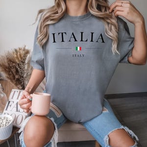 May include: A gray oversized t-shirt with the word "ITALIA" printed in black with the Italian flag and the word "ITALY" underneath.