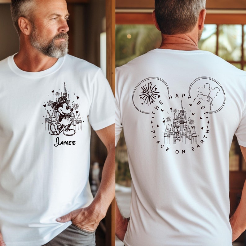 K&ouml;nnte beinhalten: Wei&szlig;es T-Shirt mit einer Schwarz-Wei&szlig;-Illustration von Mickey Mouse vor einem Schloss und dem Namen "James" darunter. Auf der R&uuml;ckseite des Shirts steht der Text "The Happiest Place on Earth."
