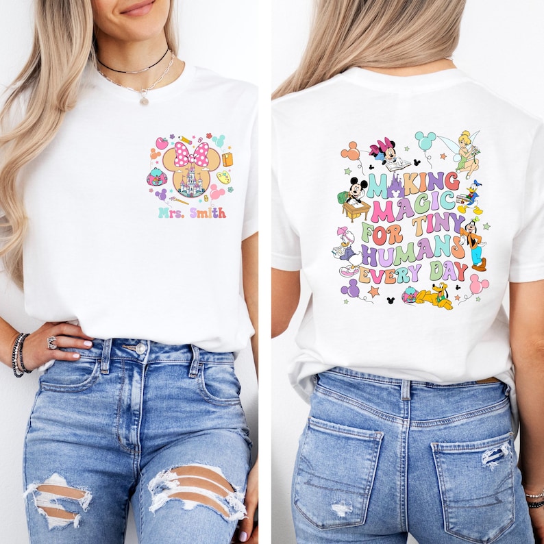 May include: White t-shirt with a colourful Minnie Mouse design, a castle, and the text "Mrs. Smith" on the front. The back of the shirt features Disney characters and the text "Making Magic For Tiny Humans Every Day".