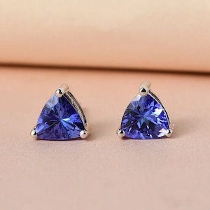 Könnte beinhalten: Ein Paar silberne Ohrstecker mit einem dreieckigen blauen Edelstein in jedem Ohrring.