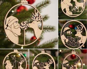 May include: Wooden Christmas ornaments featuring Santa Claus and reindeer in various scenes. One ornament shows Santa giving a lollipop to a reindeer. Another shows Santa and a reindeer looking at a map. The ornaments are hanging on a Christmas tree.