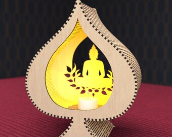 May include: A wooden candle holder shaped like a spade with a silhouette of Buddha meditating inside. The candle holder is lit with a small candle inside.