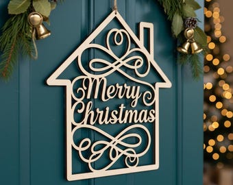 May include: A wooden house-shaped Christmas decoration with the words "Merry Christmas" cut out in a decorative font. The decoration is hanging on a teal door, with a festive garland and bells in the background.