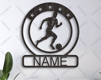 May include: A dark brown wooden wall art piece featuring a soccer player silhouette within a circular frame with stars. The word "NAME" is displayed below. The words "VECTOR DOWNLOAD", "SVG", "DXF", and "AI" are also visible.